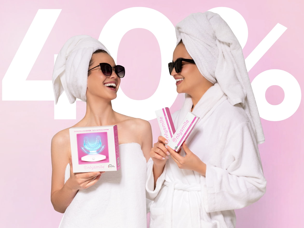 Zwei Frauen im Bademantel halten OnlySmile LED-Zahnaufhellungsset und zwei Zahnaufhellungsgelen